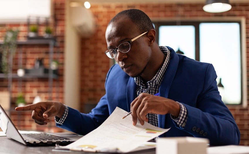 business-man-analyzing-papers-on-clipboard-to-plan-2022-01-13-00-41-54-utc