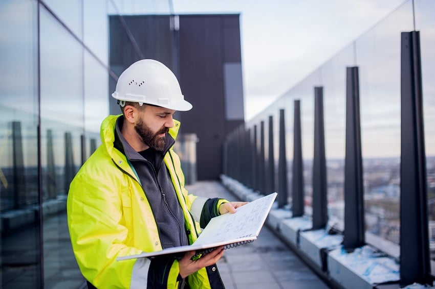 man-engineer-standing-on-construction-site-holdin-2022-02-02-04-50-37-utc