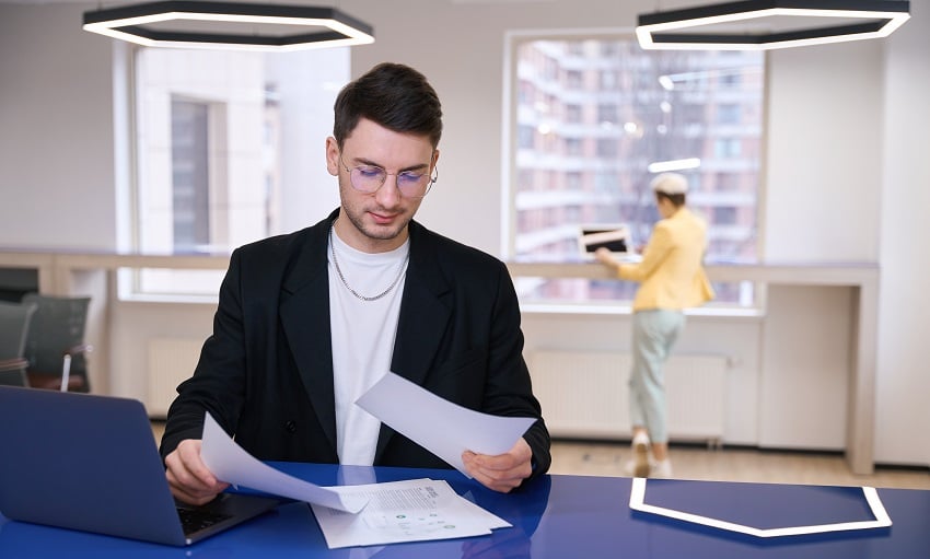 man-looking-through-documents-at-coworking-space-2023-05-22-23-13-31-utc