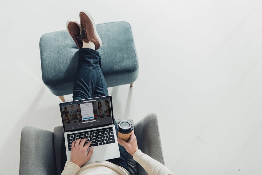 top-view-of-man-holding-paper-cup-and-using-laptop-2022-10-20-16-06-18-utc